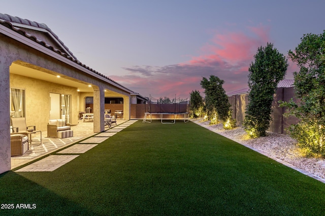 view of yard with a patio, a trampoline, and a fenced backyard