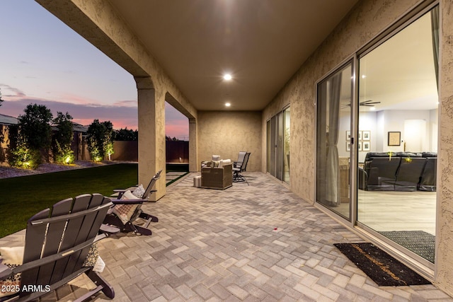 patio terrace at dusk featuring a fenced backyard