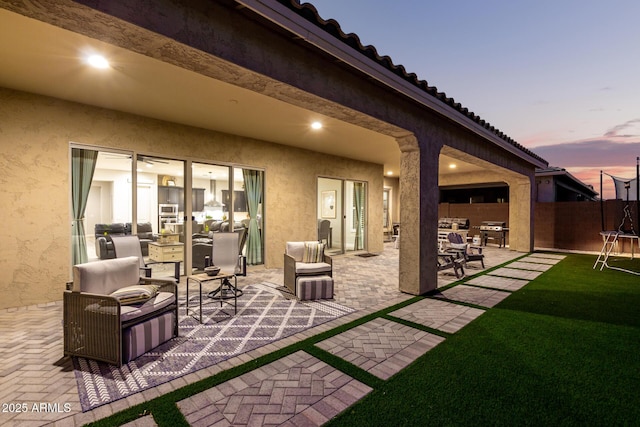 patio terrace at dusk with a grill and fence