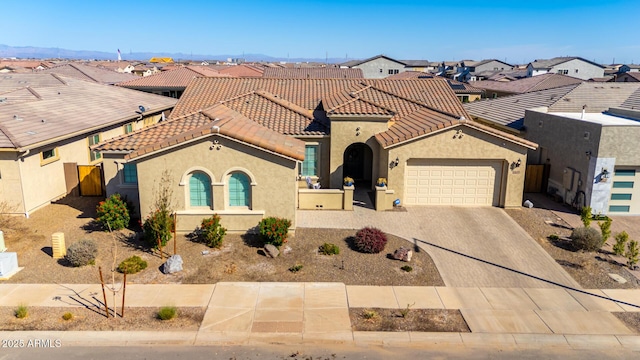 view of front of house featuring a residential view, a tiled roof, an attached garage, and stucco siding