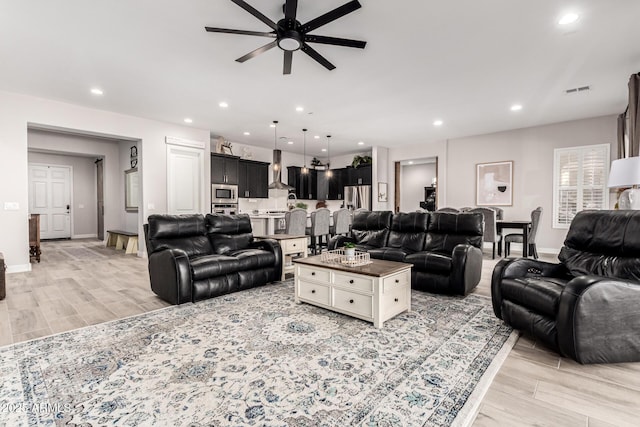 living room featuring baseboards, ceiling fan, wood tiled floor, and recessed lighting