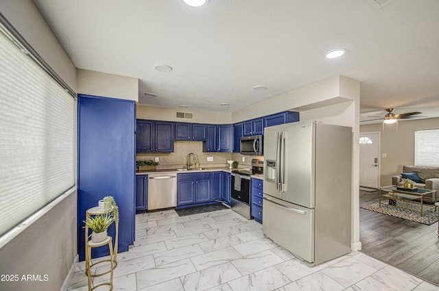 8523 W Whitton Ave, Phoenix, AZ 85037 - kitchen featuring stainless steel appliances, blue cabinetry, a sink, light marble finish floors, and a ceiling fan