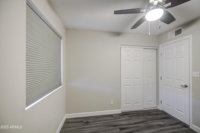8523 W Whitton Ave, Phoenix, AZ 85037 - unfurnished bedroom featuring dark wood-type flooring, baseboards, a closet, and ceiling fan