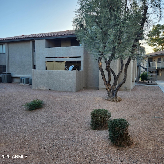 533 W Guadalupe Rd Unit 2126, Mesa, AZ 85210 - rear view of house with stairway, stucco siding, and cooling unit