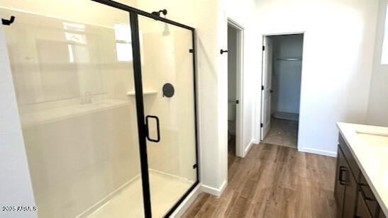 5657 S 253rd Ave, Buckeye, AZ 85326 - bathroom featuring wood finished floors, a stall shower, and vanity