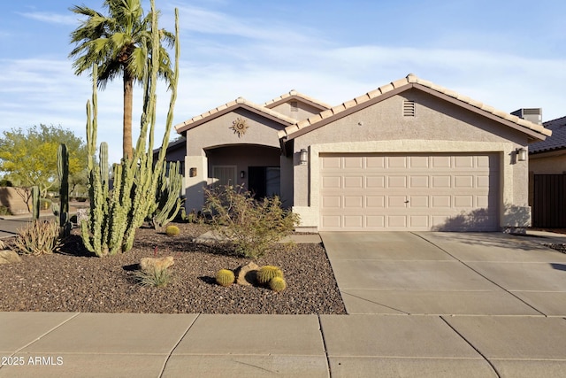 view of front of house featuring an attached garage, stucco siding, concrete driveway, and a tile roof
