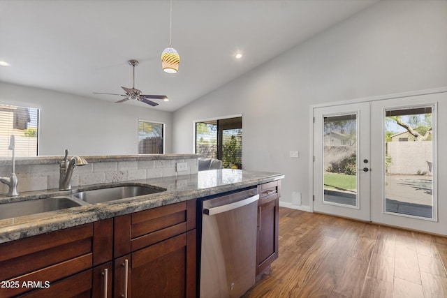 kitchen with stainless steel dishwasher, a sink, light wood-type flooring, recessed lighting, and stone counters