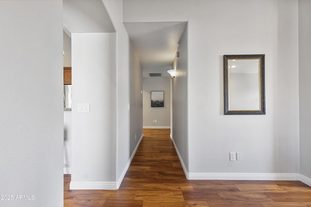 hall featuring wood finished floors and baseboards