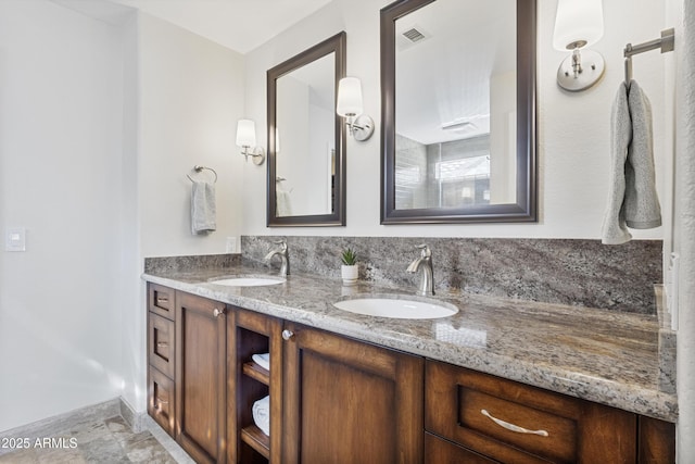 full bath featuring double vanity and baseboards