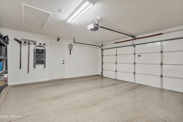 garage featuring a garage door opener and baseboards