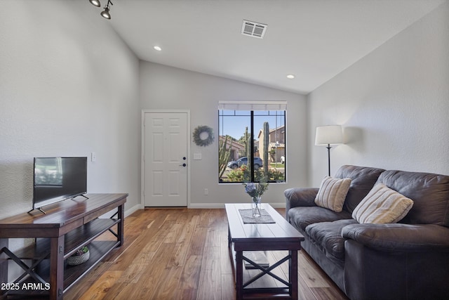 living room with lofted ceiling, hardwood / wood-style flooring, baseboards, and recessed lighting