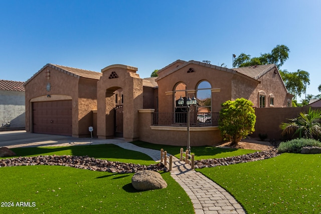 mediterranean / spanish home with a front yard and a garage