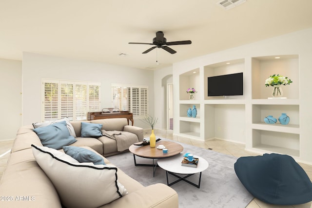 tiled living room featuring built in features and ceiling fan