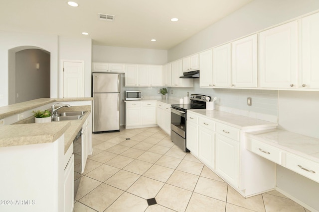 kitchen with stainless steel appliances, white cabinetry, and tasteful backsplash