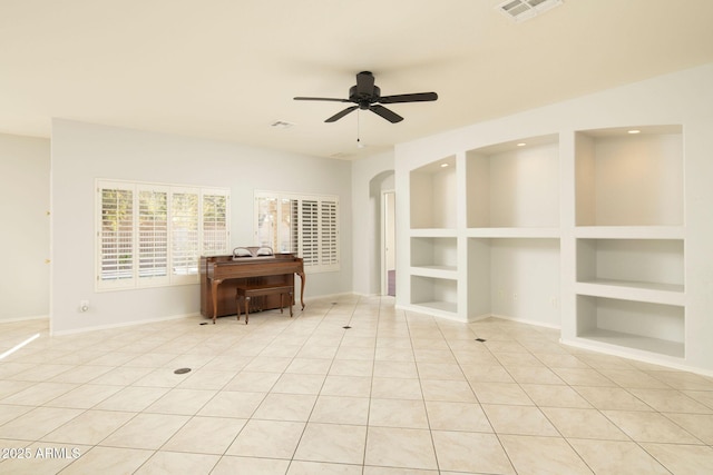 interior space featuring built in shelves, ceiling fan, and light tile patterned floors