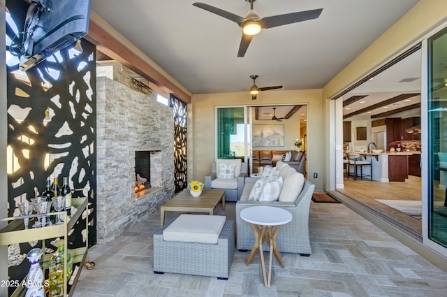 view of patio featuring ceiling fan and a stone fireplace