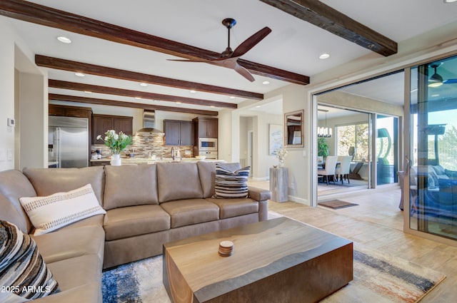 living room with ceiling fan, beamed ceiling, and light wood-type flooring