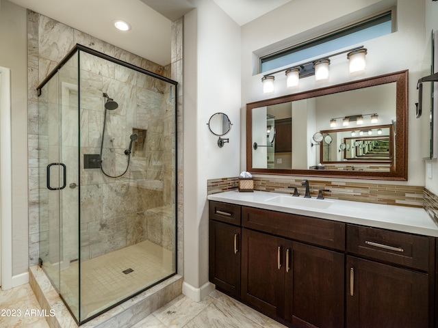 bathroom with tasteful backsplash, vanity, and a shower with shower door