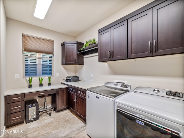 laundry area with cabinets, light hardwood / wood-style floors, and washer and clothes dryer