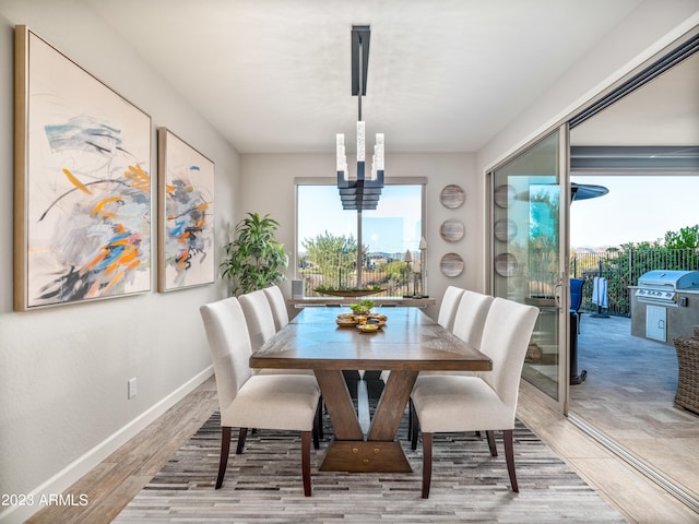 dining area with light hardwood / wood-style flooring and an inviting chandelier