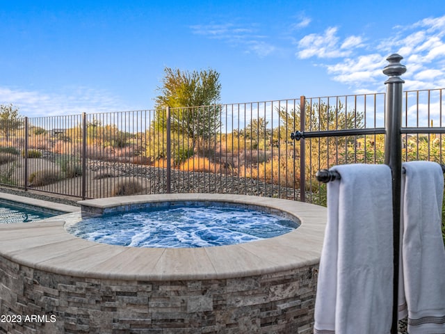 view of swimming pool featuring an outdoor hot tub