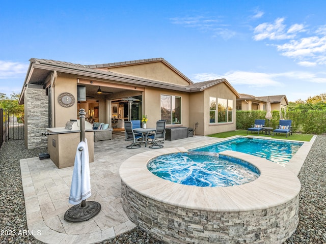 rear view of house featuring a swimming pool with hot tub, a patio area, area for grilling, and ceiling fan