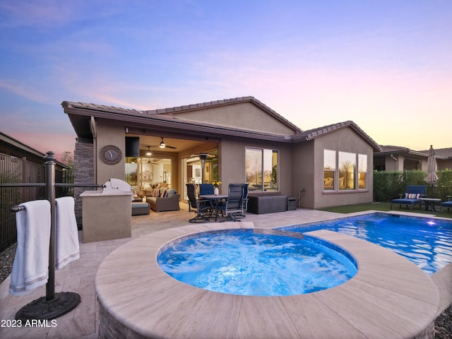 view of swimming pool with an in ground hot tub, an outdoor kitchen, outdoor lounge area, a patio, and ceiling fan