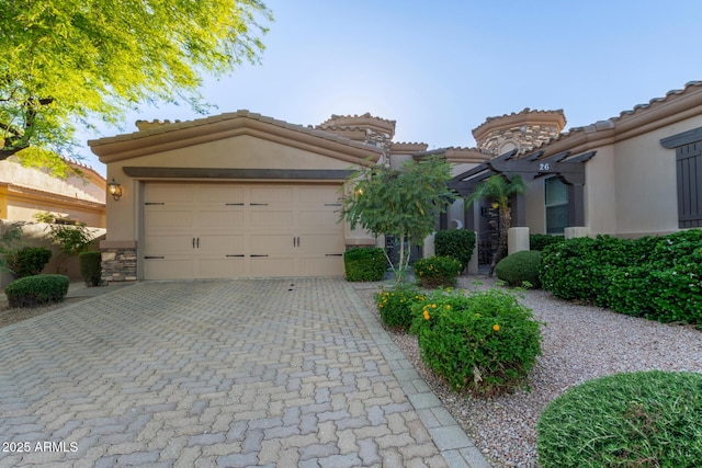 6202 E Mckellips Rd Unit 25, Mesa, AZ 85215 - mediterranean / spanish house featuring stucco siding, decorative driveway, an attached garage, a tile roof, and stone siding