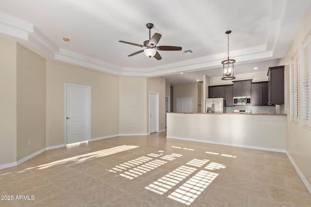 6202 E Mckellips Rd Unit 25, Mesa, AZ 85215 - unfurnished living room with a tray ceiling, light tile patterned floors, ceiling fan, and baseboards