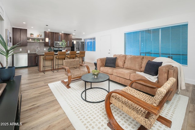 living room featuring sink and light hardwood / wood-style floors