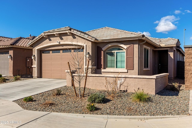 view of front facade with a garage, driveway, a tiled roof, and stucco siding