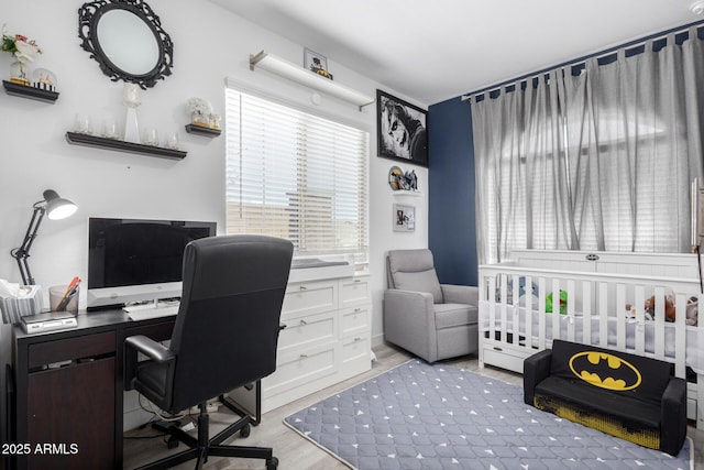 bedroom featuring a crib and wood finished floors