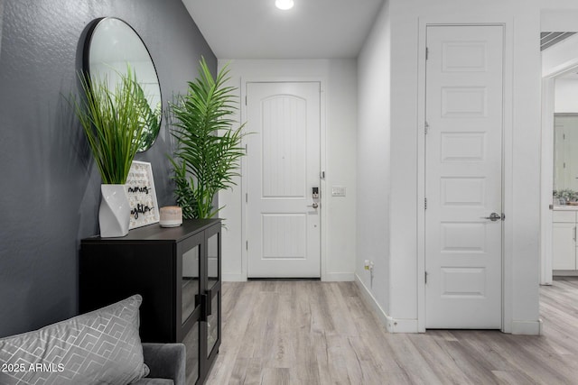 foyer with light wood-style floors and baseboards