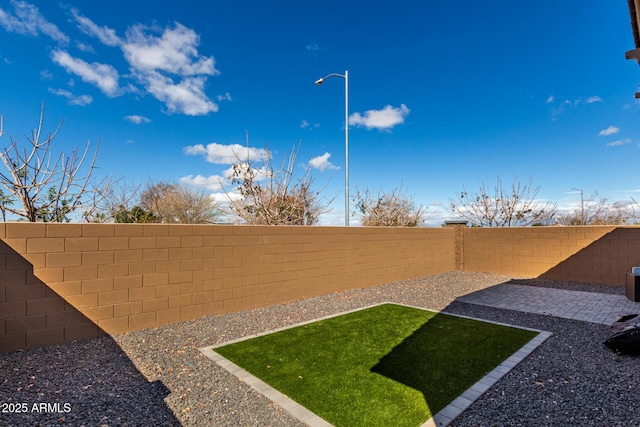 view of yard featuring a patio area and a fenced backyard