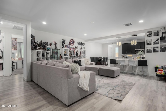 living room featuring recessed lighting, visible vents, and light wood finished floors