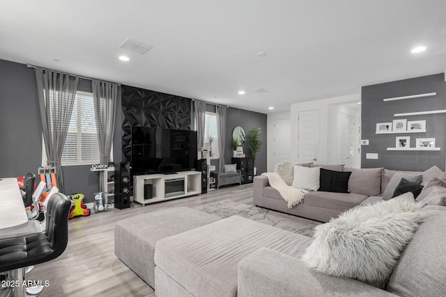 living room with wood finished floors, visible vents, and recessed lighting