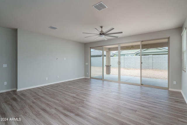 spare room featuring light wood-style flooring, baseboards, ceiling fan, and visible vents
