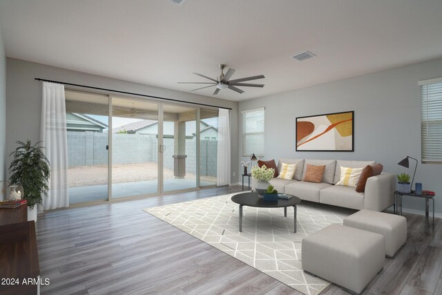 living room featuring visible vents, wood finished floors, ceiling fan, and a healthy amount of sunlight