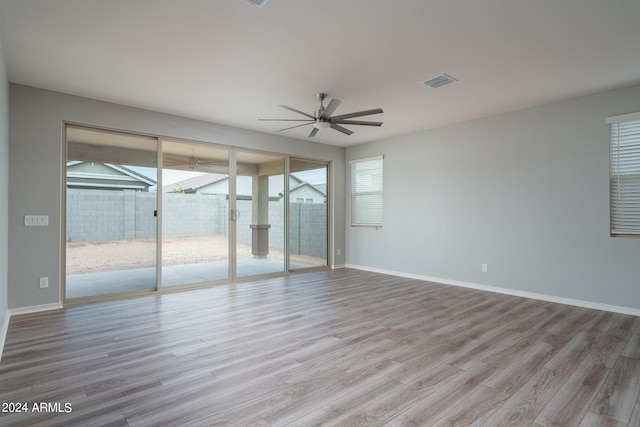 unfurnished bedroom featuring wood finished floors, baseboards, access to exterior, and visible vents