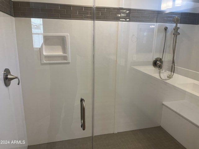 bathroom with an enclosed shower and tile patterned floors