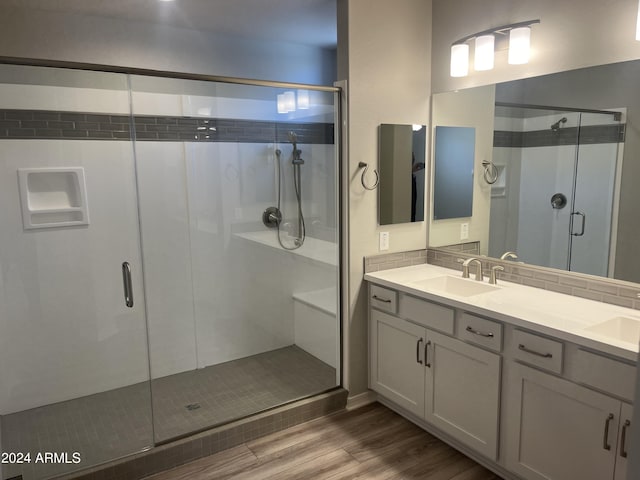 bathroom featuring vanity, walk in shower, wood-type flooring, and backsplash