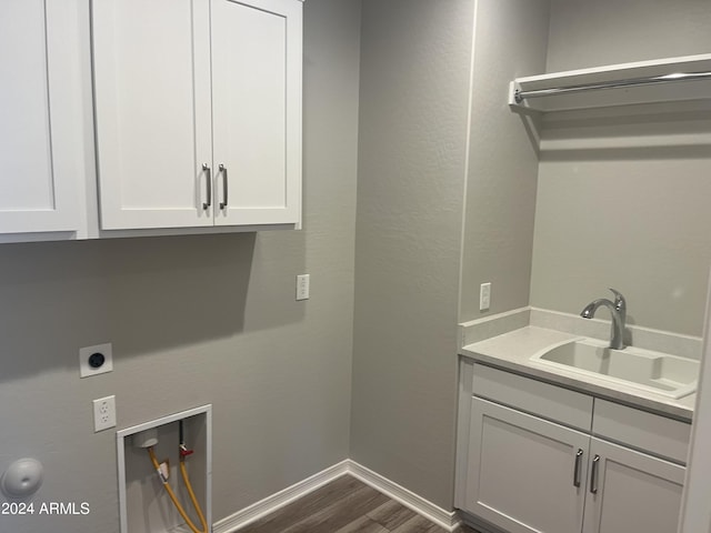 clothes washing area with dark hardwood / wood-style flooring, hookup for a washing machine, cabinets, electric dryer hookup, and sink