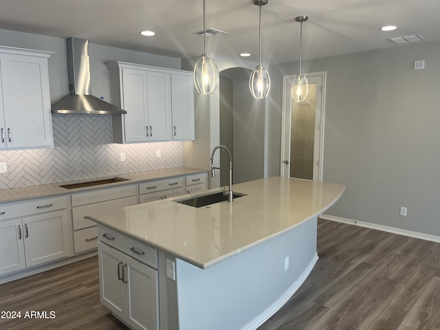 kitchen with white cabinetry, tasteful backsplash, wall chimney range hood, sink, and dark hardwood / wood-style floors