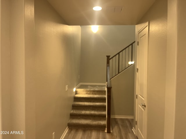 staircase with hardwood / wood-style floors