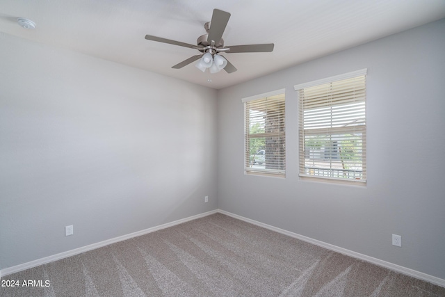 carpeted empty room with baseboards and a ceiling fan