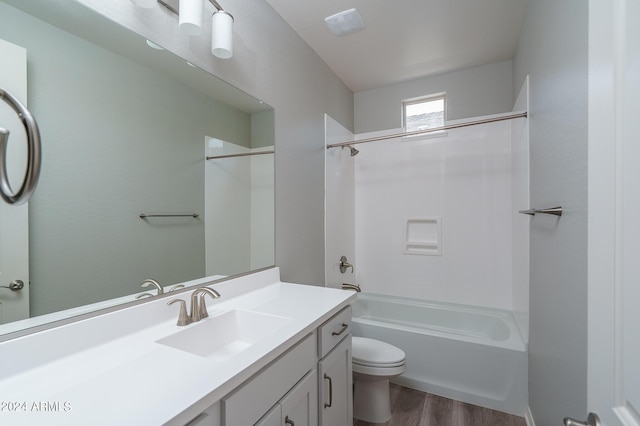 bathroom with shower / washtub combination, wood finished floors, toilet, and vanity