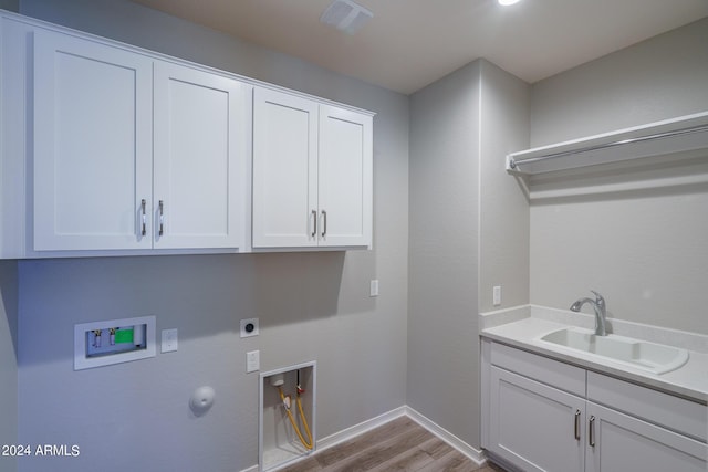 washroom featuring hookup for a gas dryer, hookup for a washing machine, a sink, electric dryer hookup, and cabinet space