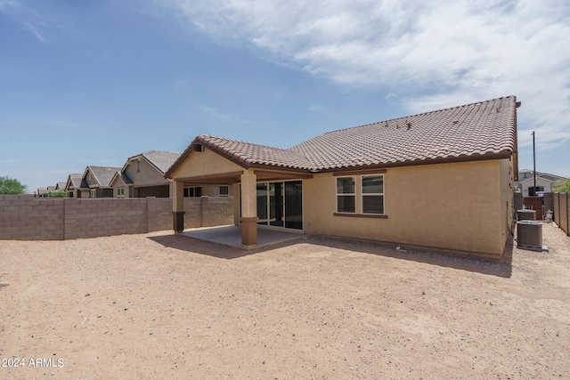 back of house featuring a tiled roof, a fenced backyard, stucco siding, cooling unit, and a patio area