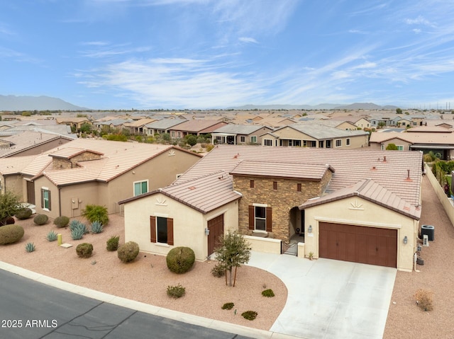 view of front of house with a residential view, stone siding, a tile roof, and a mountain view