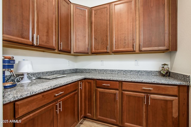 kitchen with light stone countertops and brown cabinetry